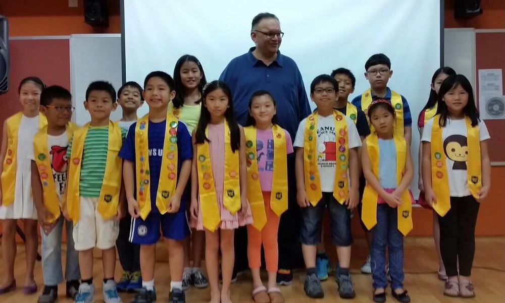 Ian with young students at a graduation ceremony